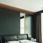 Dark fluted wall panels forming a full-height feature elevation in a modern bedroom
