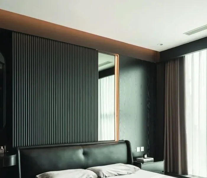 Dark fluted wall panels forming a full-height feature elevation in a modern bedroom