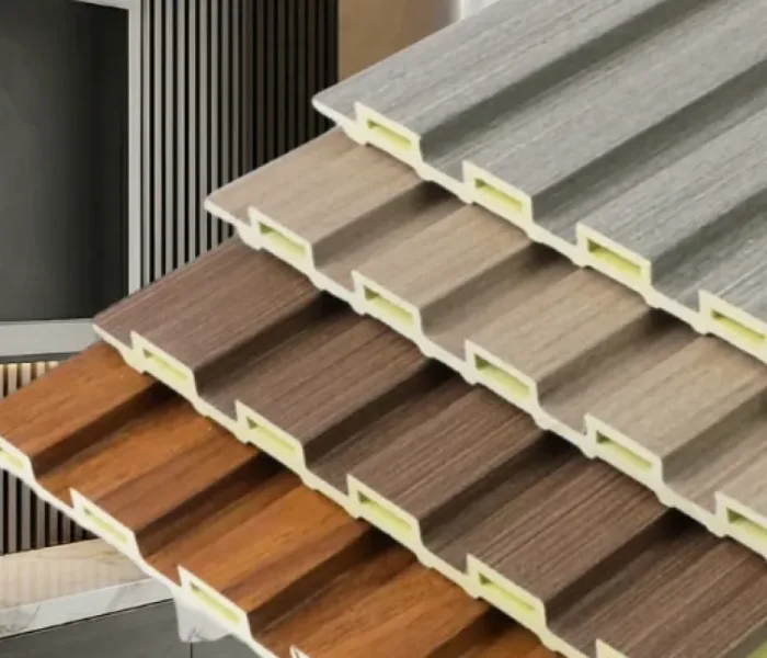 Close-up of three fluted wall panels in different wood and stone finishes, showing groove profile and hollow edge