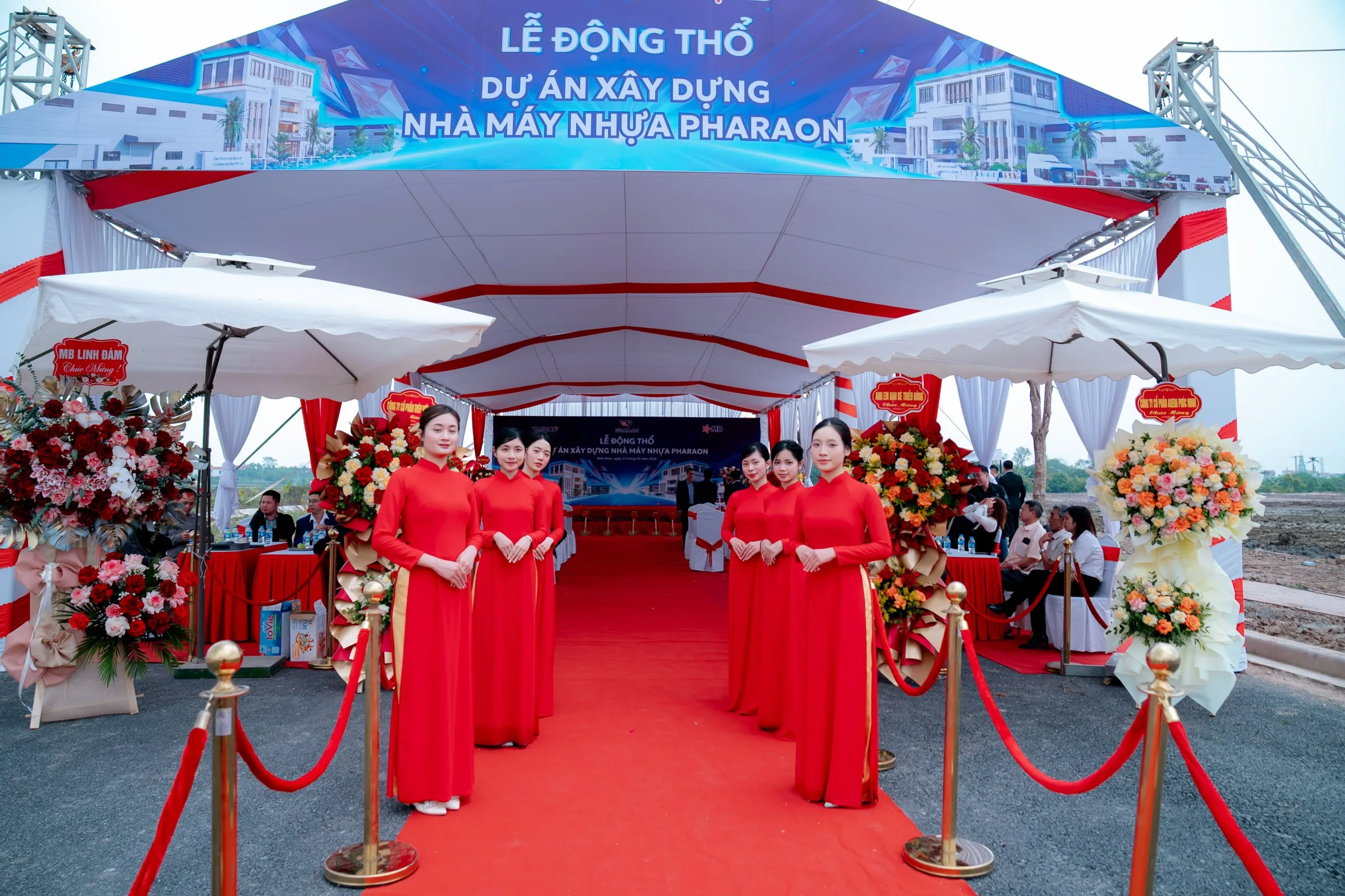 Red-carpet entrance to the Pharaon factory groundbreaking ceremony, hosts in ao dai