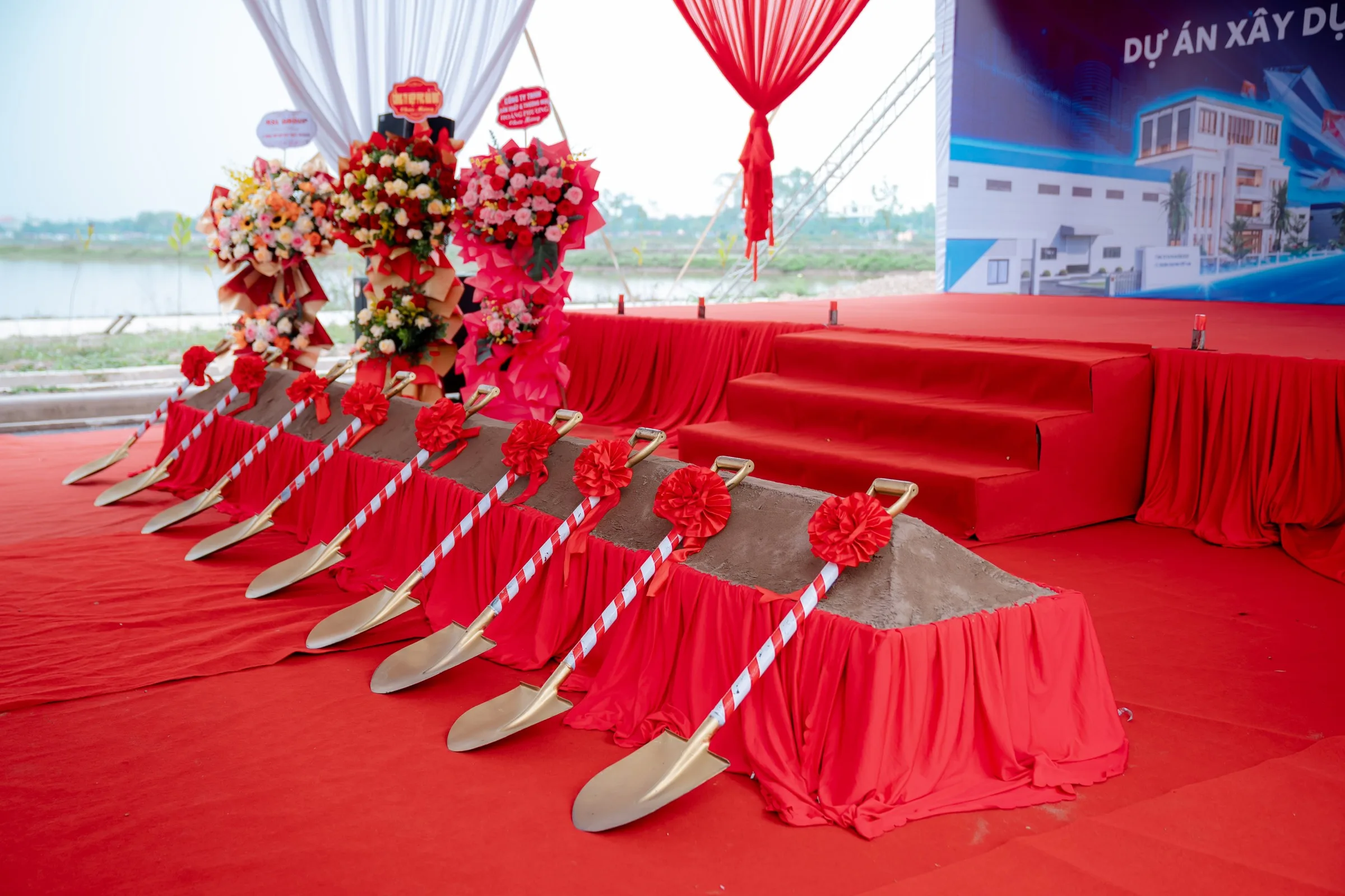 Row of gold ceremonial shovels set into the soil mound before the ceremony